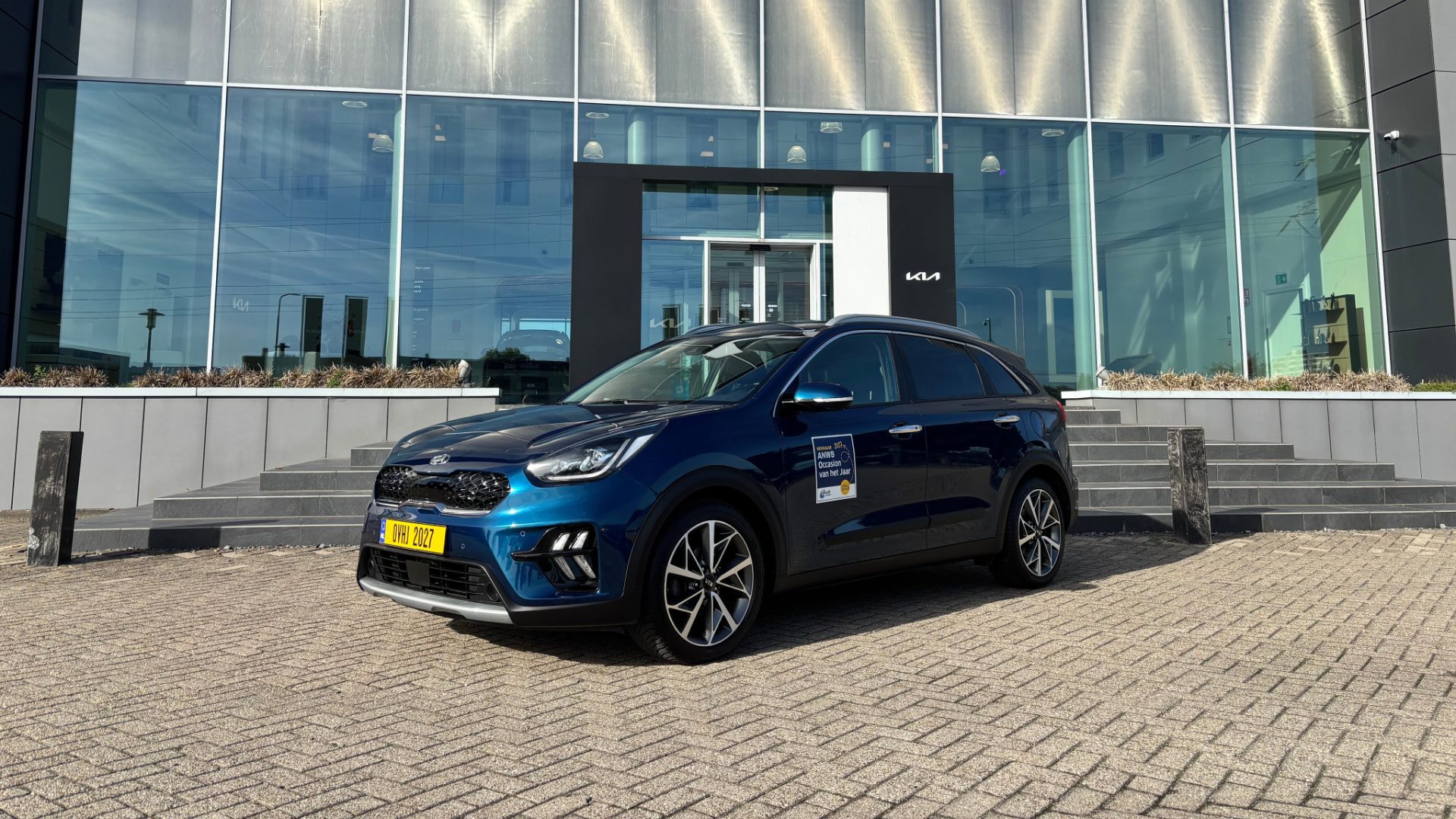 Blauwe Kia Niro voor het hoofdkantoor van Kia Nederland